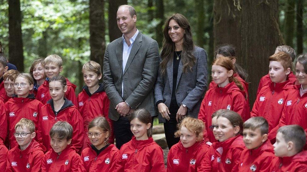 The couple posed with youngsters for a photo