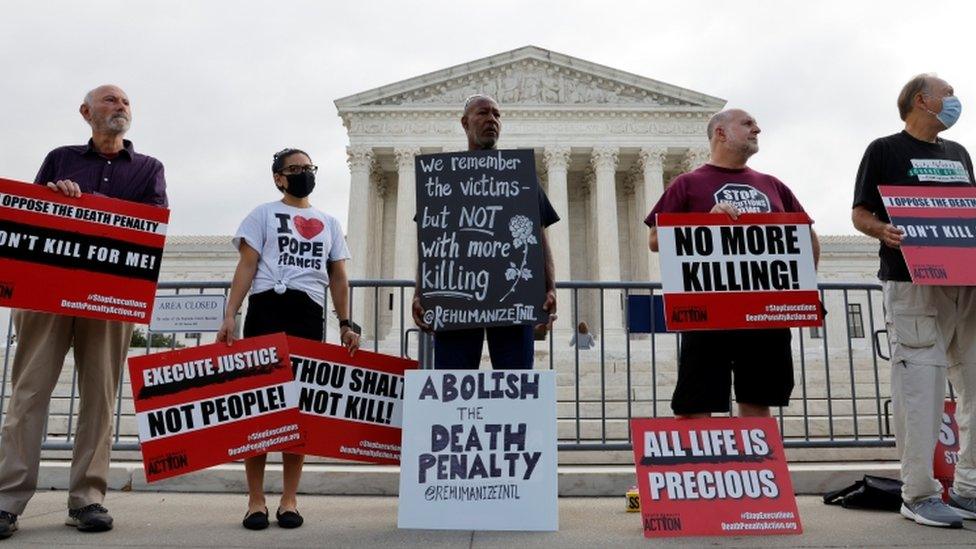 A small group of demonstrators rally against the death penalty outside the U.S. Supreme Court building