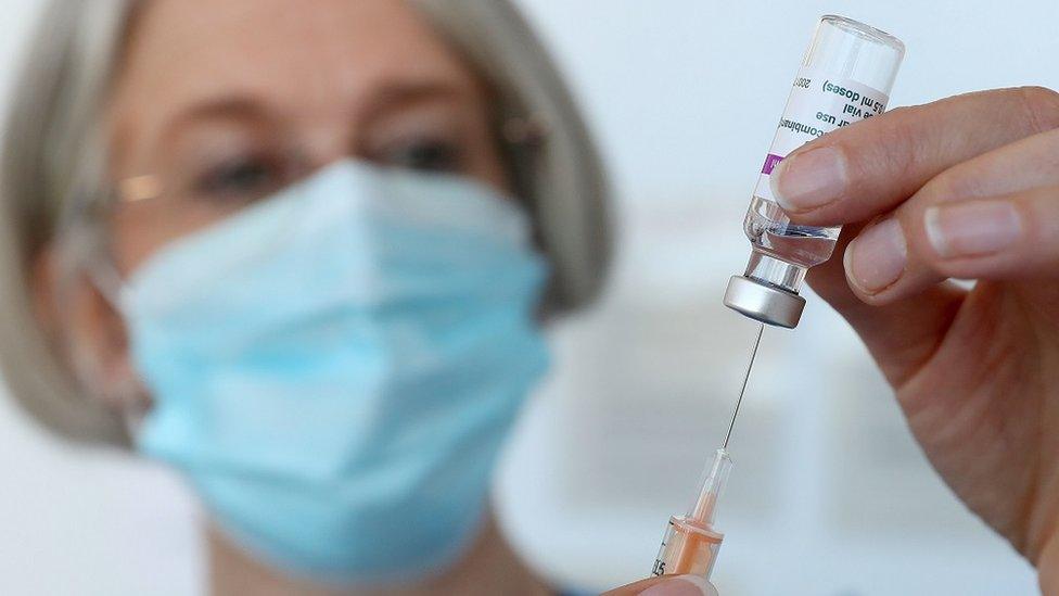 A medical professional holds a syringe