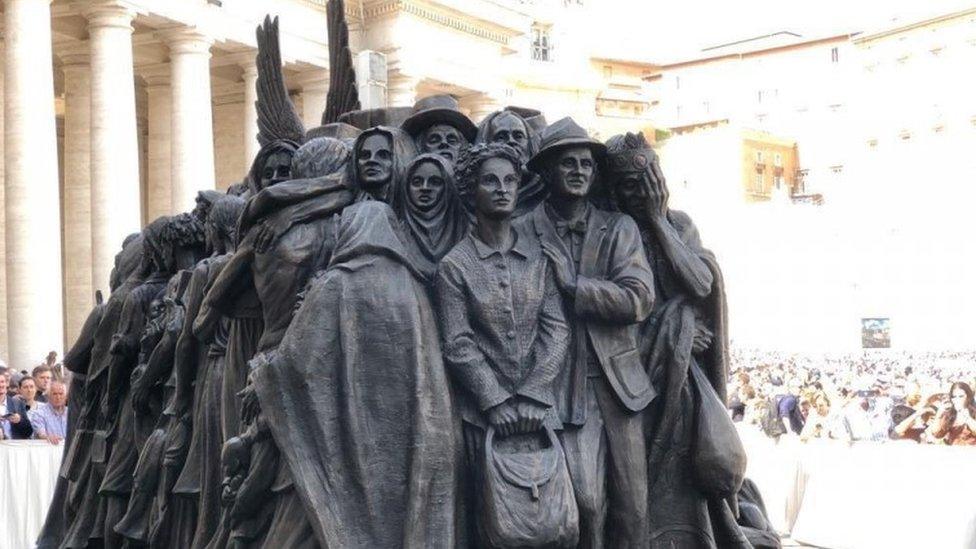 Depictions of refugees towards the back of the "Angels Unaware" sculpture