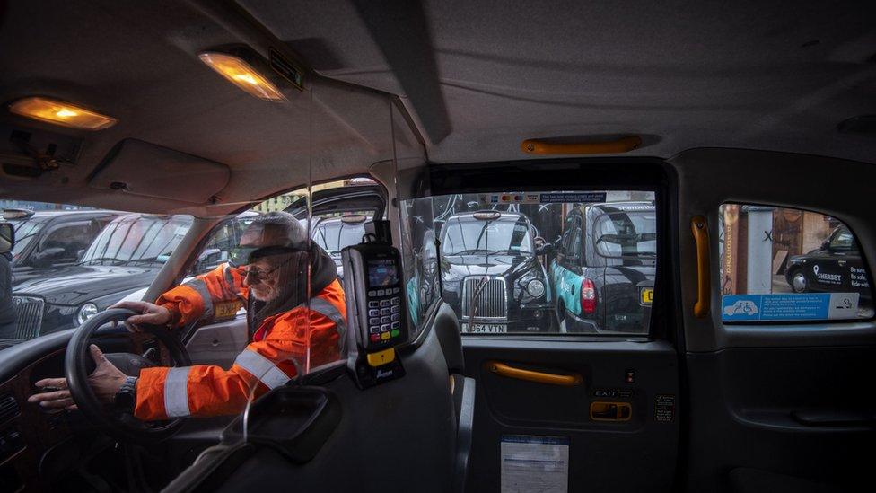 An engineer works on a de-licensed black cab in a yard at Sherbet London in east London