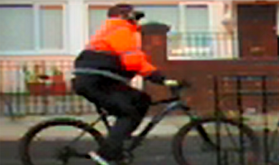 cyclist in orange jacket