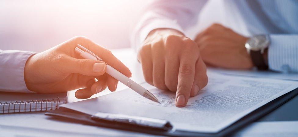 Two people signing a contract