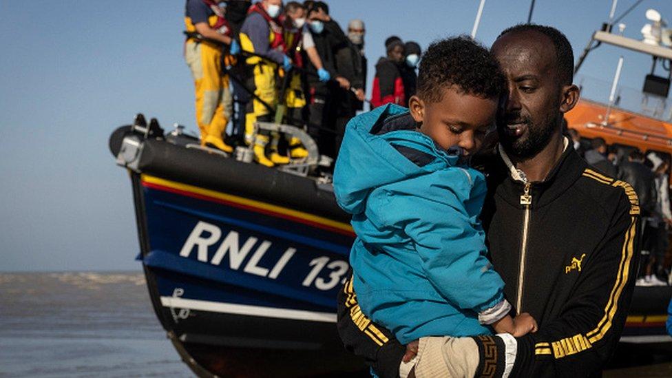 A man holds a child near a RNLI vessel