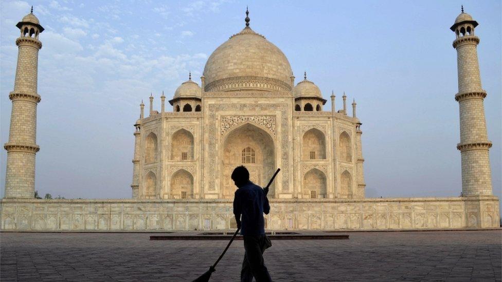 2013 file photo of worker sweeping in front of Taj Mahal in Agra, India