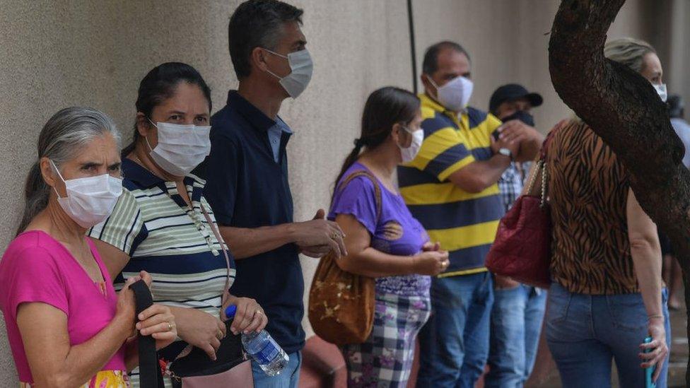 Residents line up to receive the Coronavac vaccine against COVID-19, in Serrana