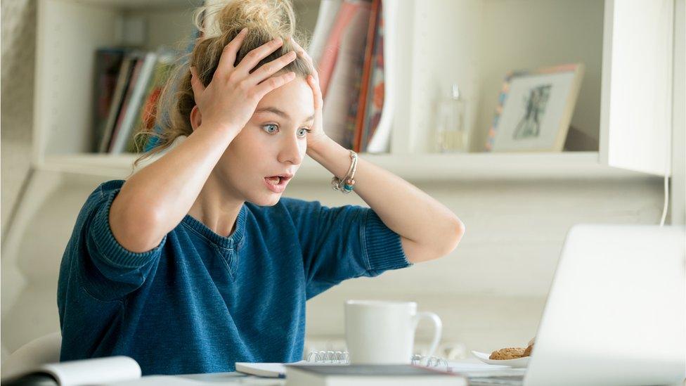 Woman holds head in shock