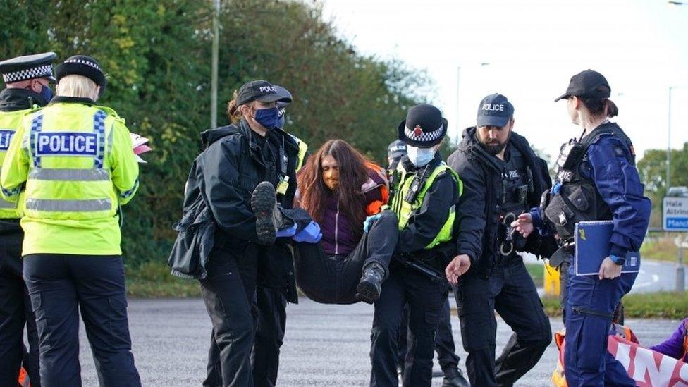 Protester being carried away by police officers