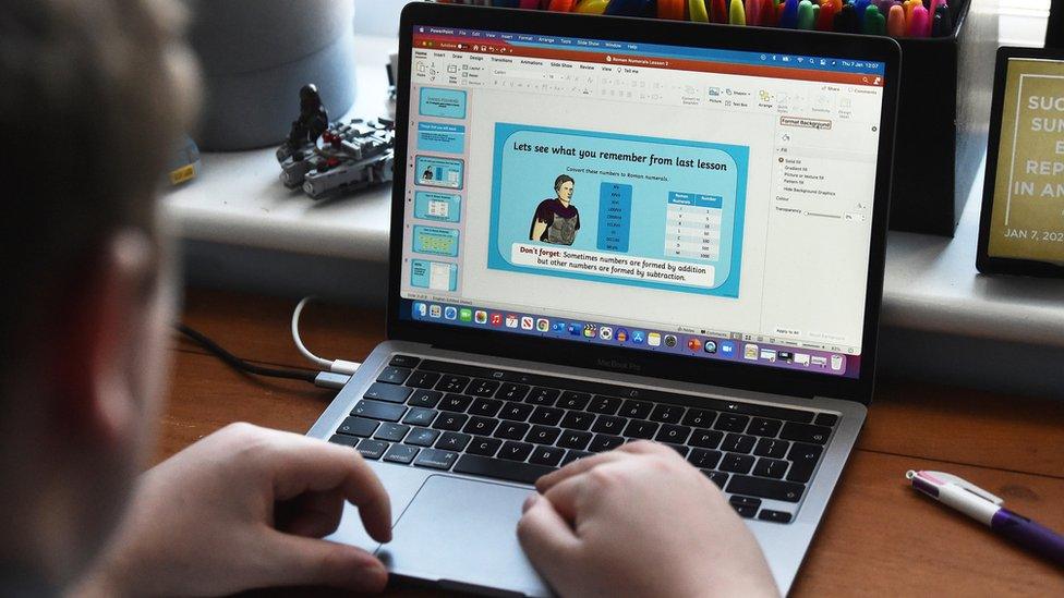 Primary school student does a maths lesson on his laptop