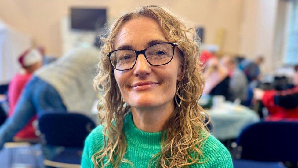 Kathyrn Ford smiling at the camera wearing a green jumper