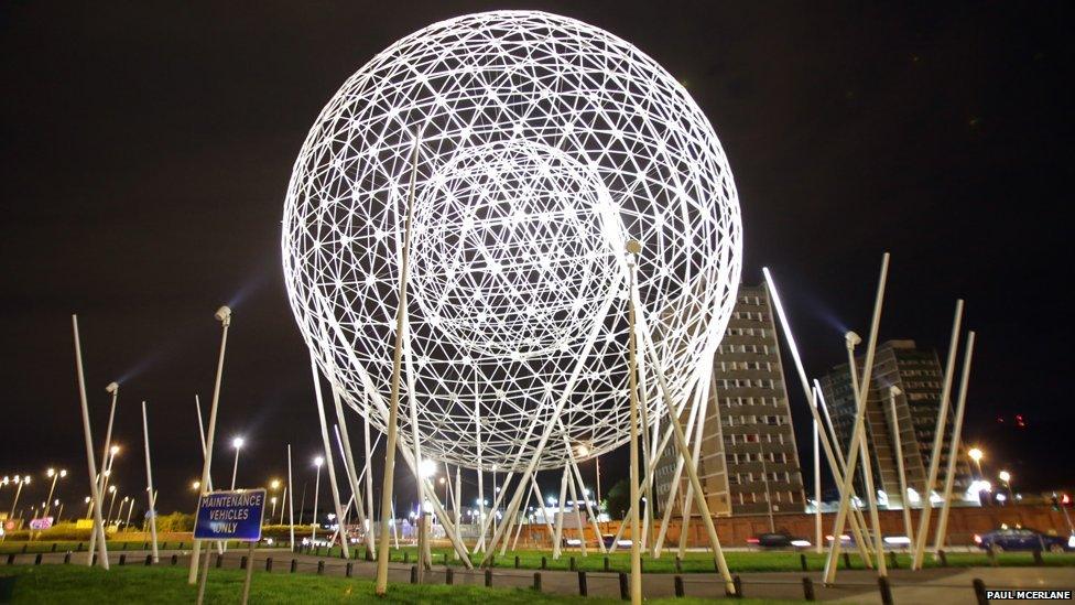 Spherical metal sculpture at night