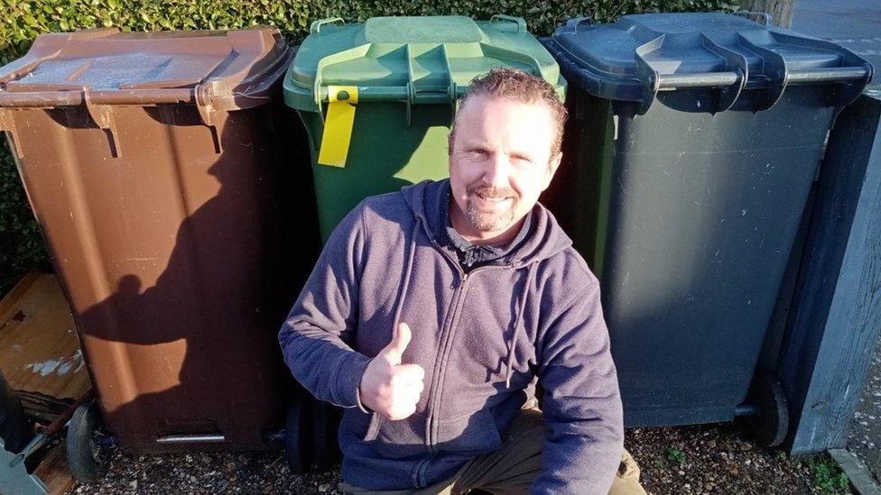 Dave Clark in front of some bins