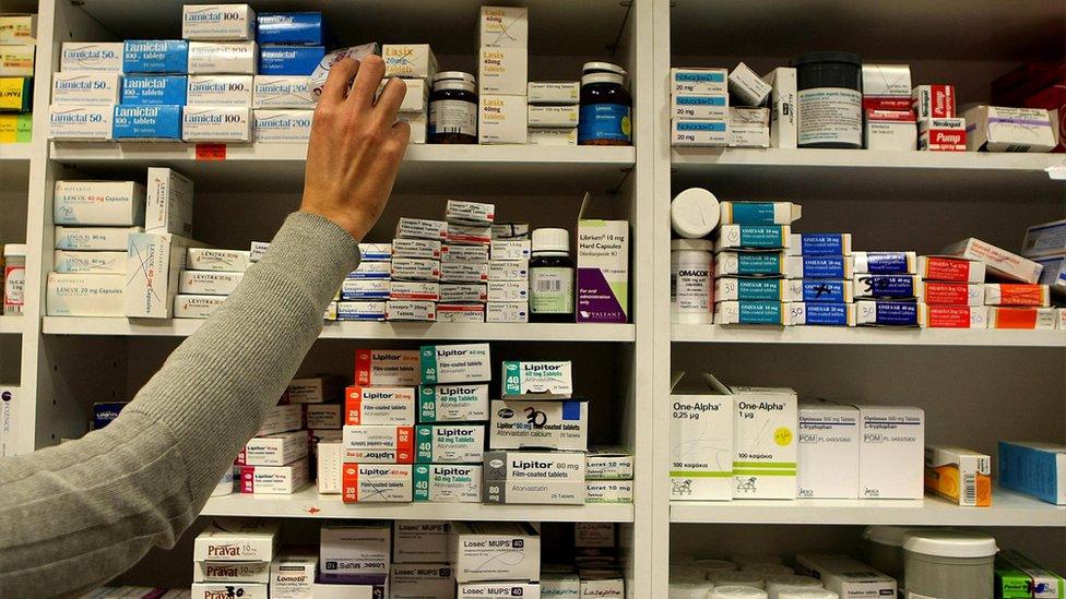 A pharmacist stocking shelves at a chemist