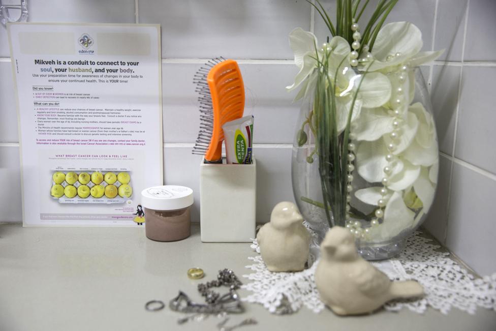 A poster for breast cancer awareness is seen inside the changing room of a mikveh in Jerusalem. In Israel, where around 750,000 women go to the mikva each month, charities are taking the initiative to train the female mikvah attendants who work there to look out for signs of cancer. (Photo by Heidi Levine for The BBC).