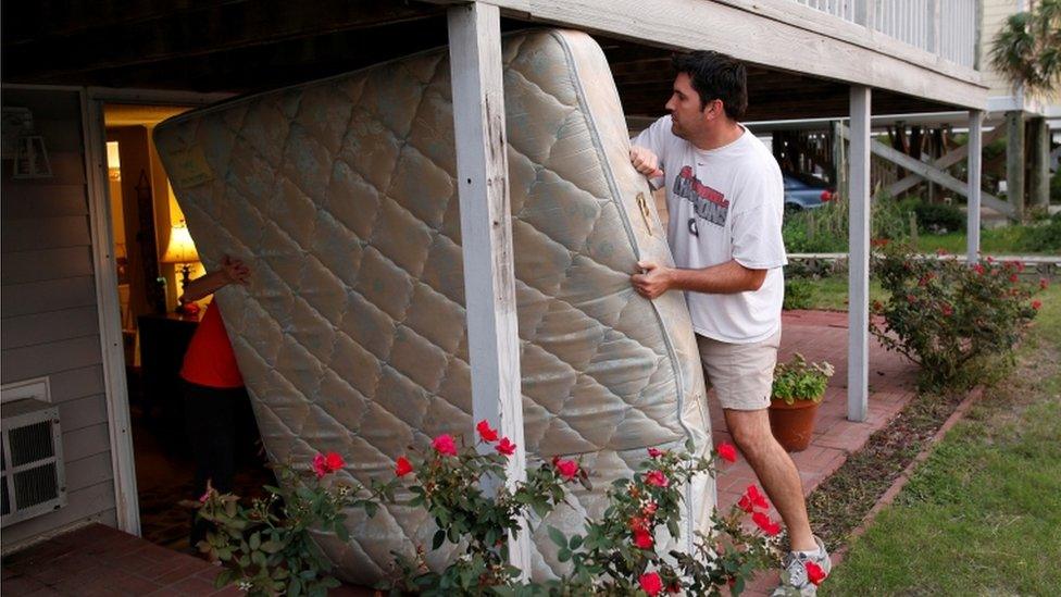 A man and a woman moving a mattress from a house in South Carolina on 4 October 2016