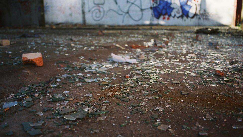 Broken glass and graffiti on wall