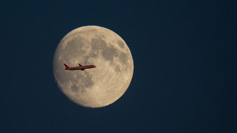 Plane passes across surface of the Moon