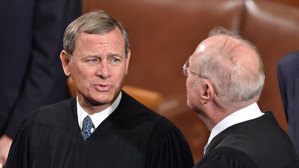 Chief Justice John Roberts talks to Justice Anthony Kennedy.