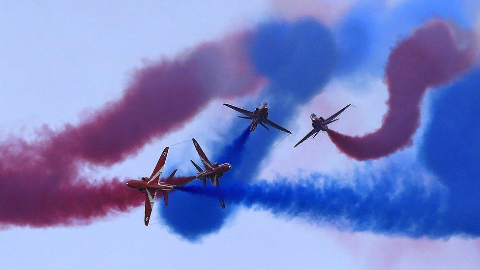 Red Arrows flying with smoke coming out of the back of the jets