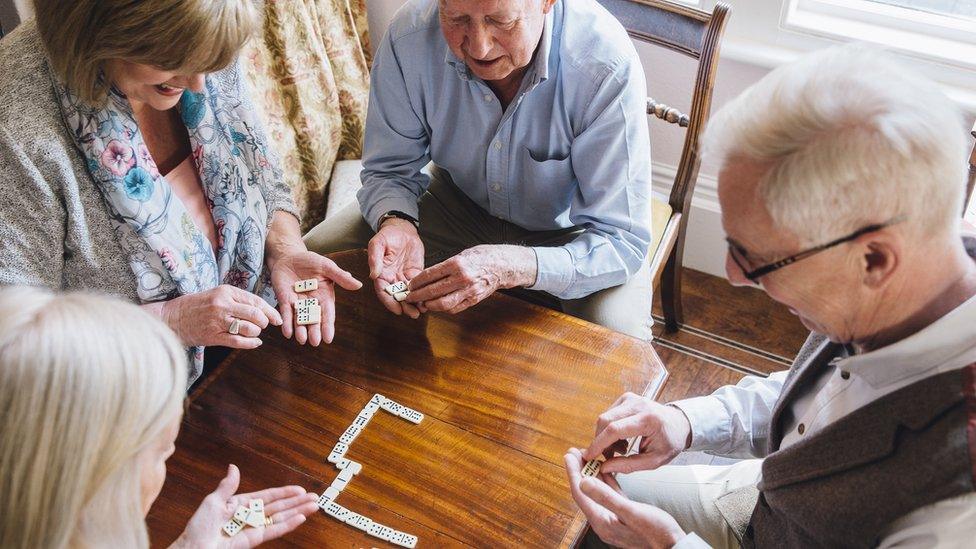 Group of elderly people playing dominoes