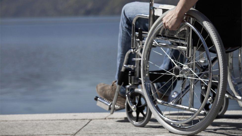 Man in wheelchair sitting by water - generic image