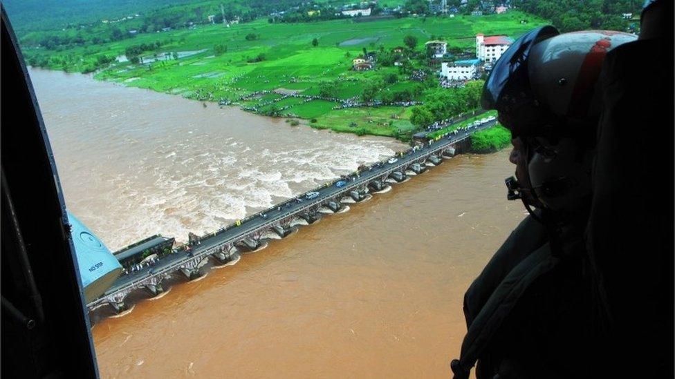 This photo released by the public relations office of Indian Defence shows an old bridge that collapsed in a flooded river in western Maharashtra state, India, Wednesday, Aug. 3, 2016.