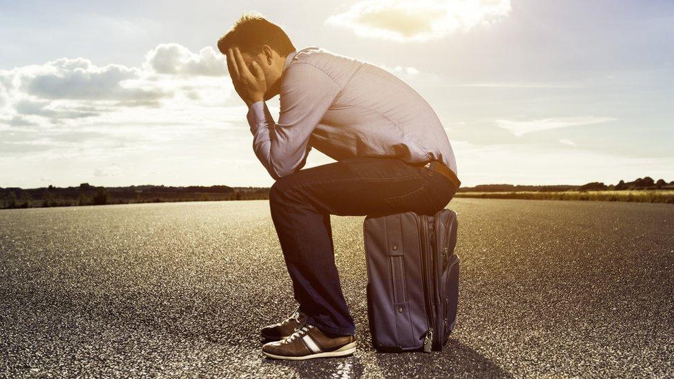 Man sits on suitcase