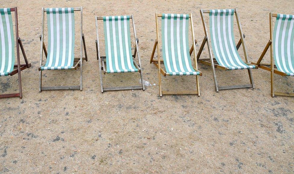 Deckchairs are seen on parched grass in Hyde Park in London.