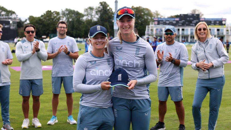 England's Freya Kemp (R) is presented with her debut cap by team mate Danni Wyatt (L)