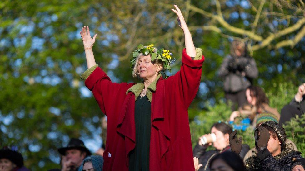 A woman taking part in a sun rise ceremony at Glastonbury Tor, Somerset