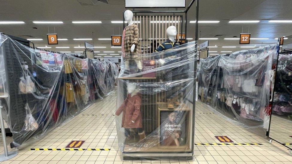 Clothes rails covered in cellophane in Sainsburys in Cardiff