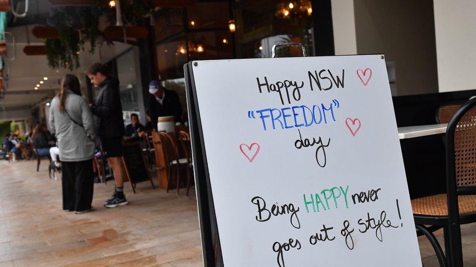 A sign outside a cafe reads: "Happy NSW 'Freedom' Day. Being happy never goes out of style"