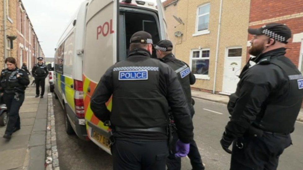 Officers with police van doors open