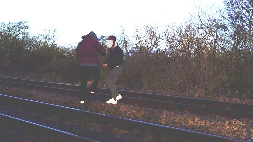 Teenage girls on railway tracks