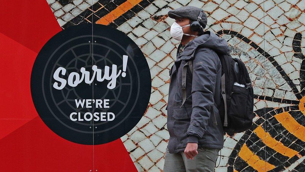 Man walking past a closed shop in Manchester city centre