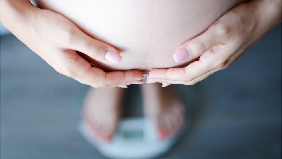 Pregnant woman on scales