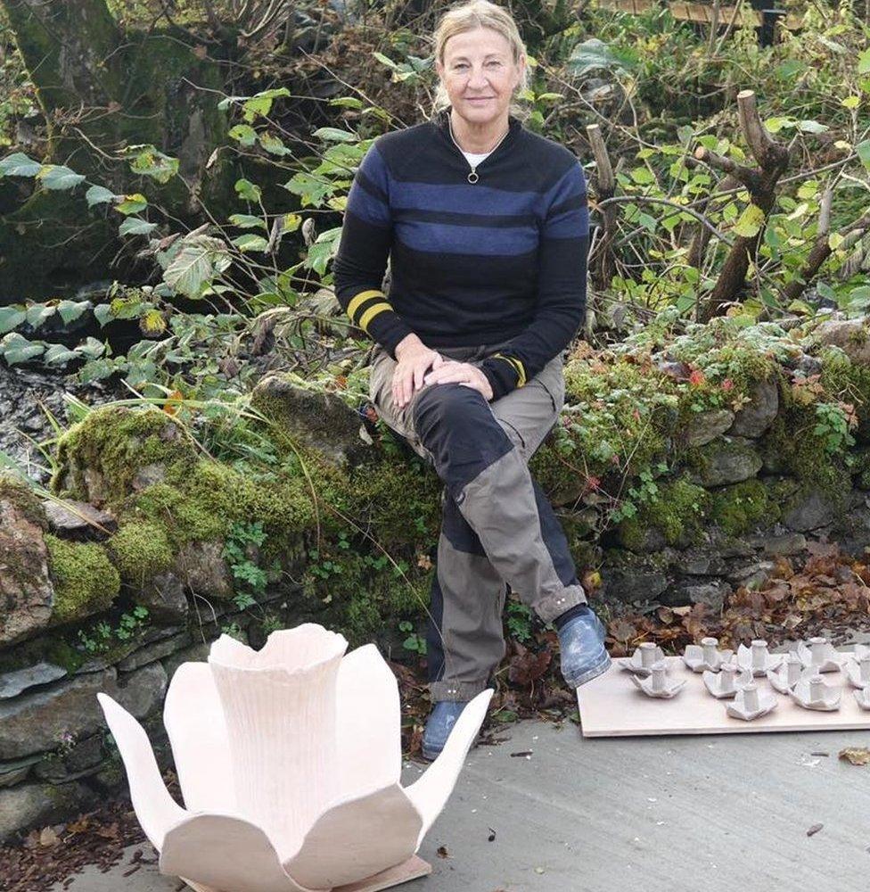 Helen Ratcliffe sitting alongside a prototype unglazed daffodil