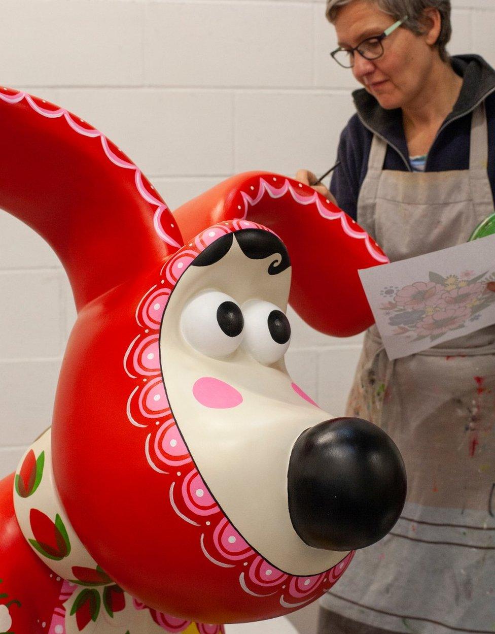 Artist painting a sculpture