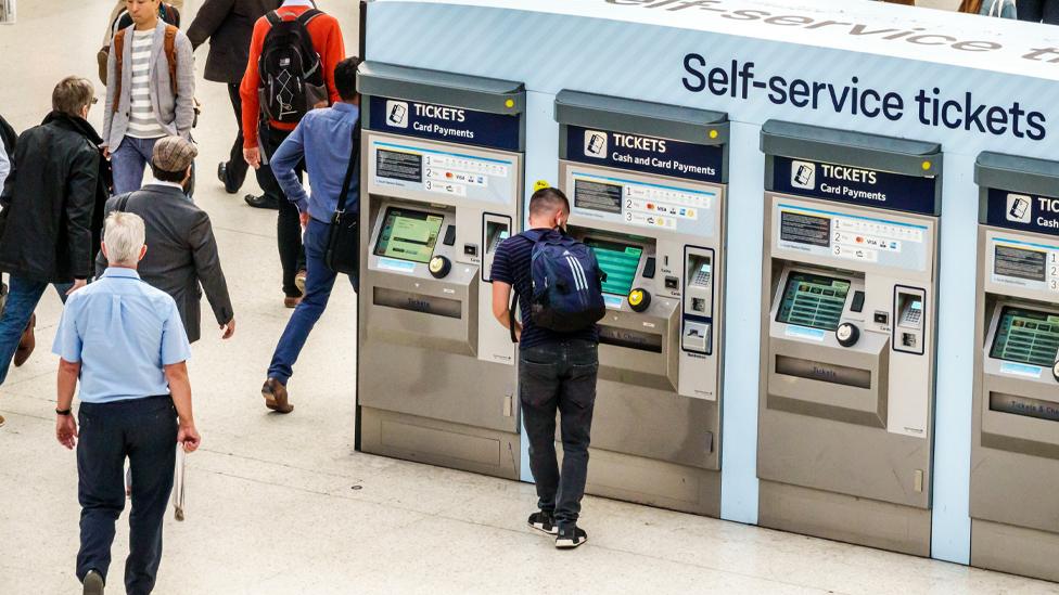 Commuters at a ticket machine kiosk