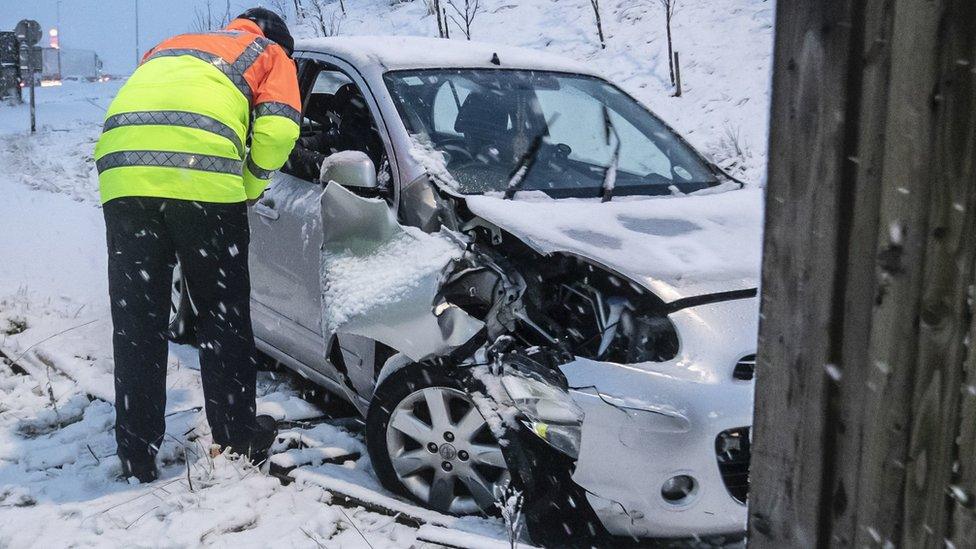 Emergency worker talks to driver whose car crashed