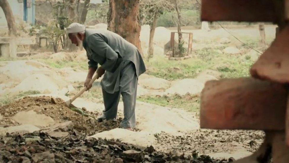 Mohammad Shareef levelling a grave