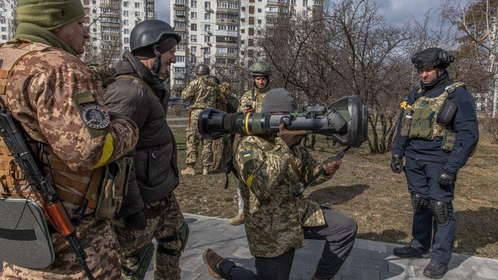 Image shows Ukrainian soldier holding an NLAW anti-tank missile