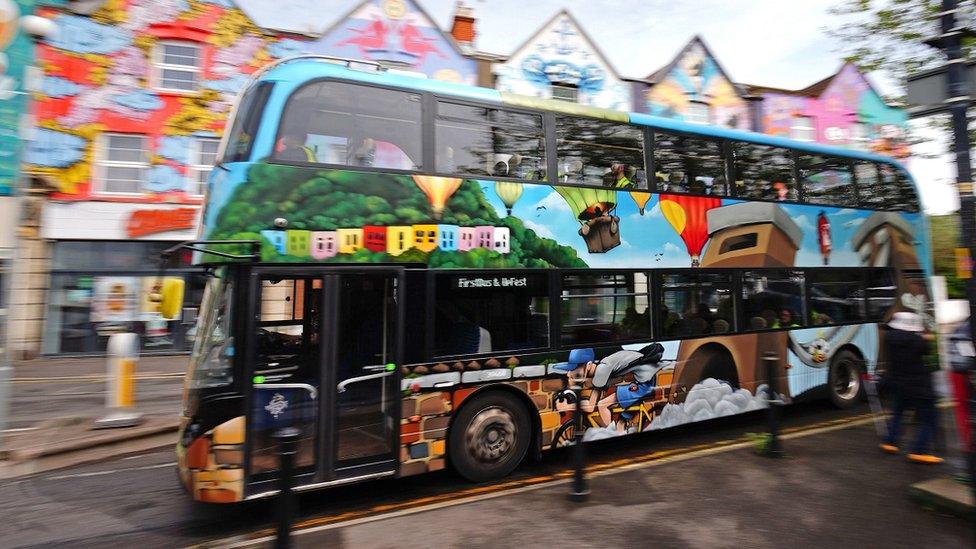 A First Bus in Bristol painted in murals for Upfest by Cheo travels down North Street in Bedminster