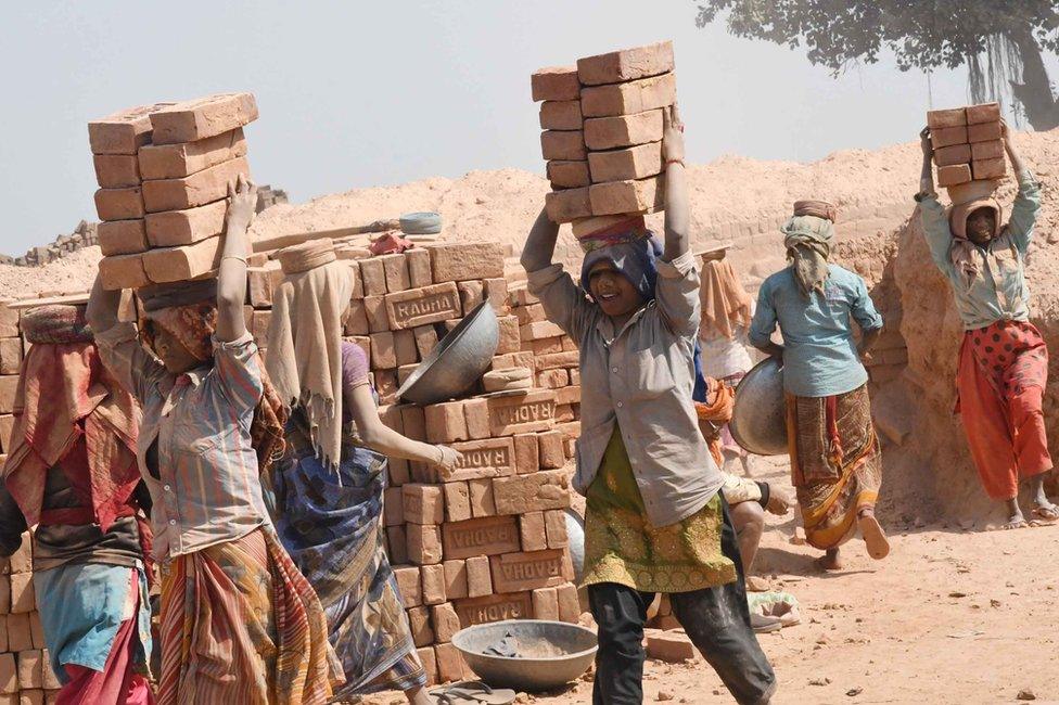 Women carry bricks at a brick kiln in Patna, India