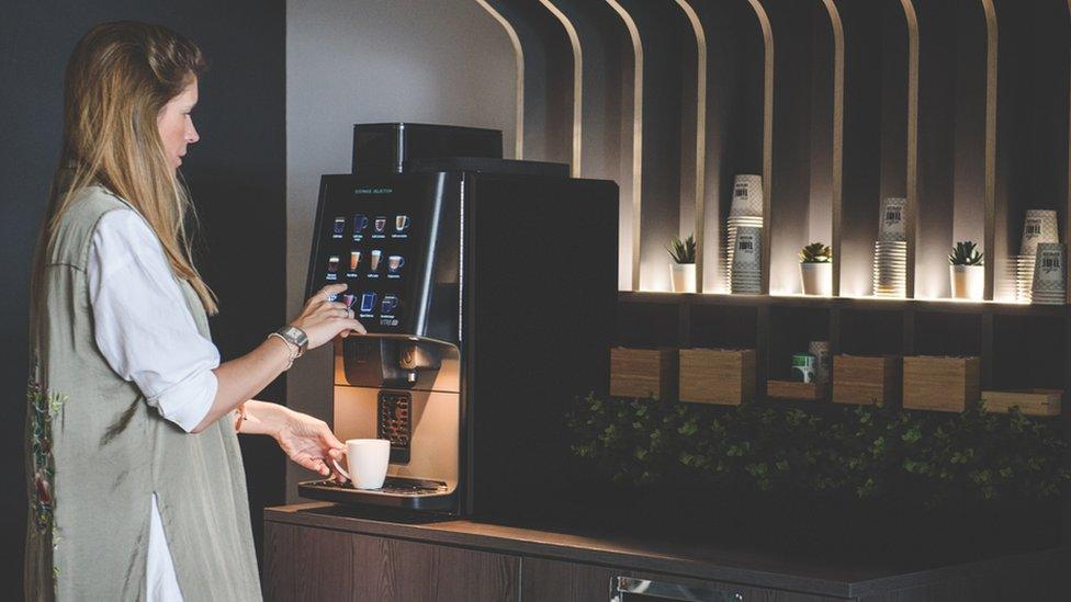 A woman using a no-touch Coffetek vending machine