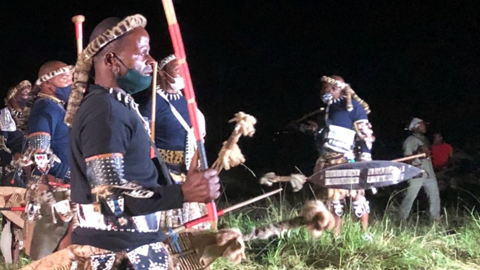 Zulu men in traditional warrior outfits at night in Nongoma, South Africa - March 2021