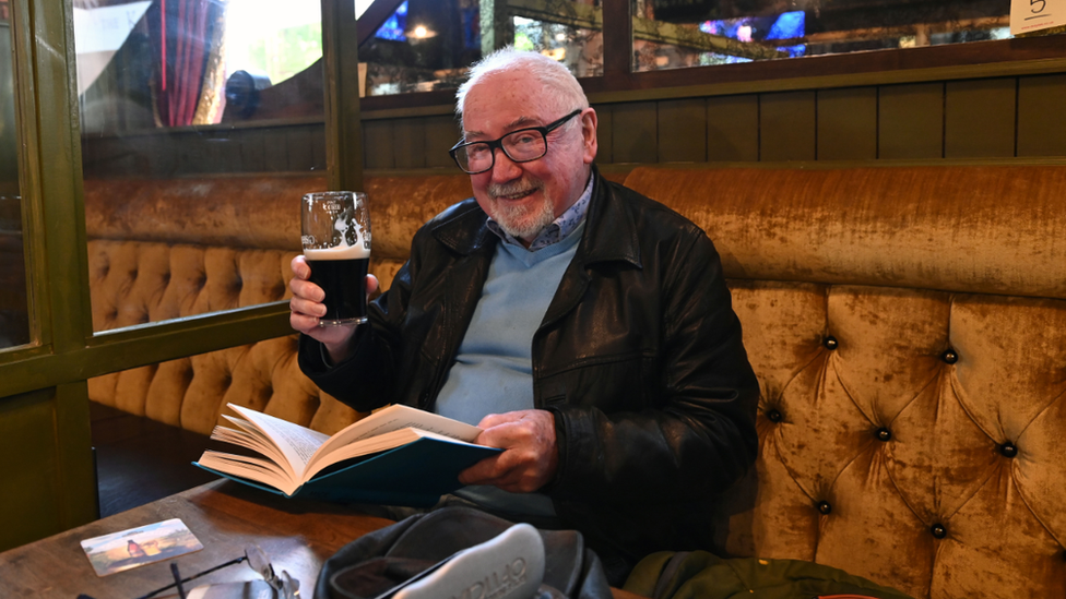 Man with book and a beer