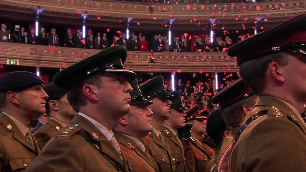 Poppies fell from the ceiling over members of the Royal Navy, the Army and Royal Air Force who stood in the centre of the hall