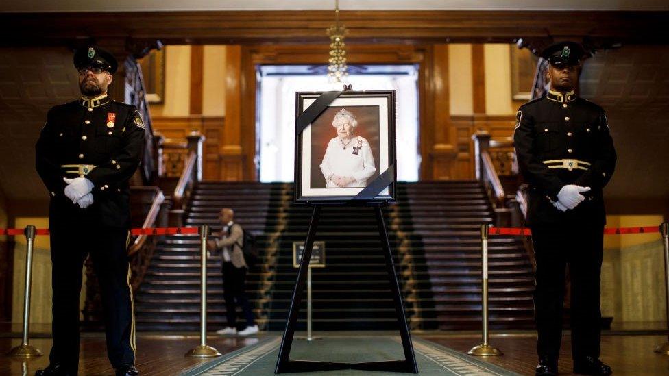 A portrait of the Queen draped in black ribbon