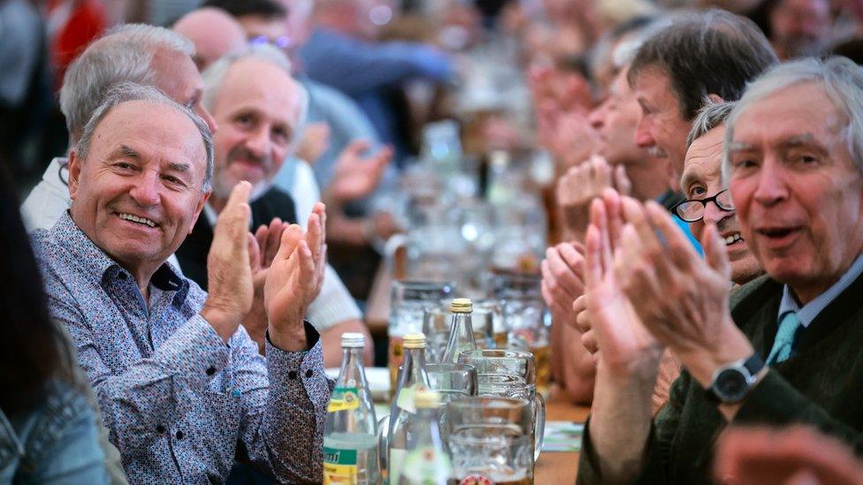 Supporters of Freie Wähler leader and Bavarian Deputy Premier Hubert Aiwanger applaud at a campaign event in a beer tent